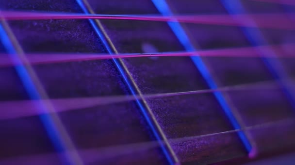 Akusztikus gitárhúr neonfényekkel megvilágítva — Stock videók