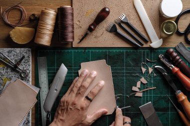 Bitkisel, bronzlaşmış deriyle çalışıyor. Deri ve el işi aletleri..