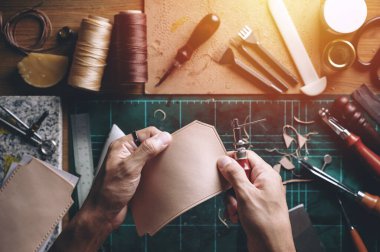 Bitkisel, bronzlaşmış deriyle çalışıyor. Deri ve el işi aletleri..