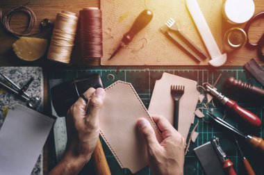 Bitkisel, bronzlaşmış deriyle çalışıyor. Deri ve el işi aletleri..