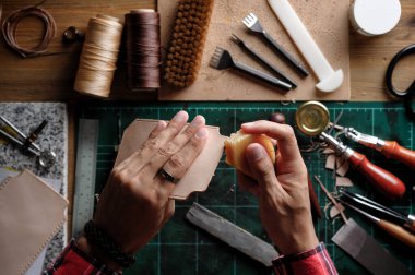 Bitkisel, bronzlaşmış deriyle çalışıyor. Deri ve el işi aletleri..