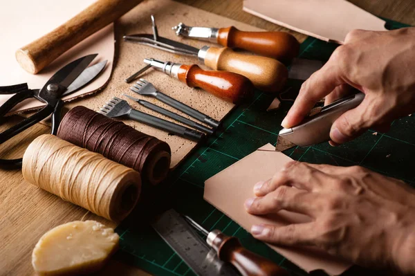 Bitkisel, bronzlaşmış deriyle çalışıyor. Deri ve el işi aletleri..