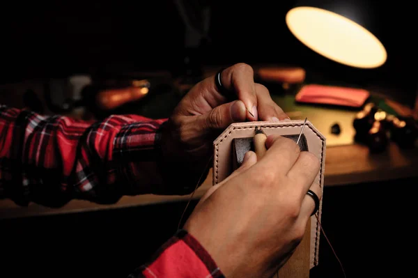 Sewing the vegetable tanned leather by hand. Leather and the craft tools.