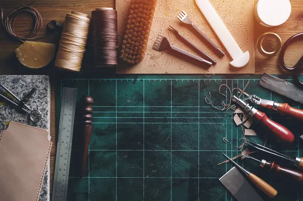 木製の机の上の革の作業道具の平らなレイアウト ストック写真