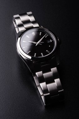 closeup luxury automatic wristwatch for men with black dial and stainless steel bracelet. clipart