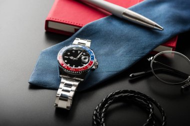 Siyah düğmeli, mavi ve paslanmaz çelik bileziği olan erkekler için yakın plan lüks kol saati..