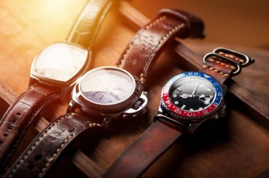 closeup luxury wristwatch for men with black dial blue-red bezel and leather strap. wristwatch with vintage men's objects. clipart