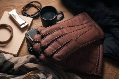 Bir çift erkek kahverengi deri eldiven ve diğer erkek aksesuarları..