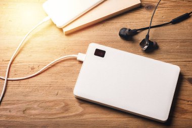 Akıllı telefon beyaz güç bankasıyla şarj ediliyor. Beyaz güç bankasına yakın çekim. 