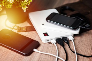 Boş akü akıllı telefonunu beyaz enerji bankasıyla şarj ediyor. Sığ alan derinliği.