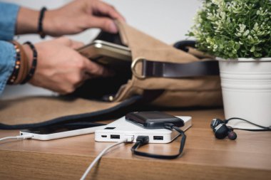 Boş akü akıllı telefonunu beyaz enerji bankasıyla şarj ediyor. Sığ alan derinliği.