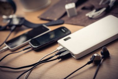 Boş akü akıllı telefonunu beyaz enerji bankasıyla şarj ediyor. Sığ alan derinliği.