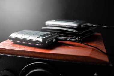 Akıllı telefonun bataryasını siyah güç bankasıyla şarj etmek. Güç bankası görüntüsüne odaklanmış sığ alan derinliği.