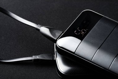 Akıllı telefonun bataryasını siyah güç bankasıyla şarj etmek. 