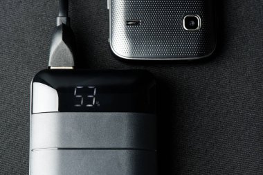 Akıllı telefonun bataryasını siyah güç bankasıyla şarj etmek. 