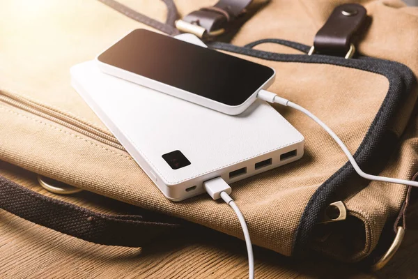 smartphone charging with white power bank. close-up at white power bank.