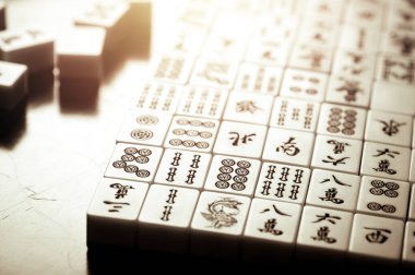 Many old mahjong tiles on wooden table. Mahjong is the ancient asian board game.