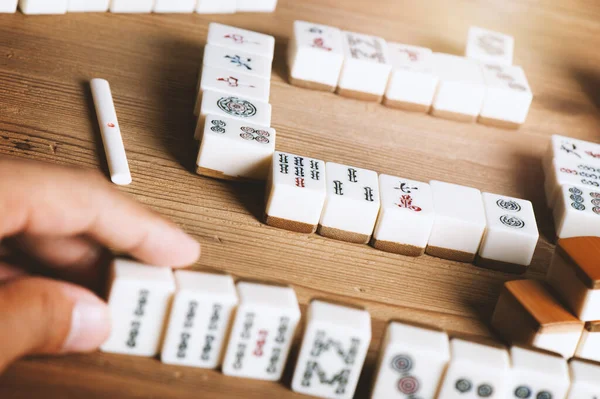 O mahjong na mesa antigo jogo de tabuleiro asiático fecha a imagem