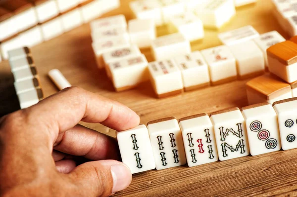 O mahjong na mesa antigo jogo de tabuleiro asiático fecha a imagem