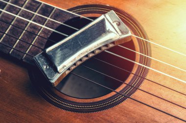 Eski bir akustik gitarın üzerinde duran klasik ahşap mızıka..