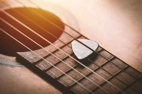 Closeup guitar pick on an old classical guitar. A guitar pick is a plectrum used for guitars.