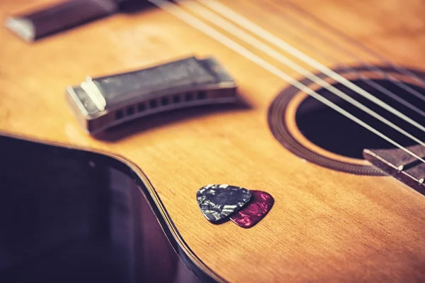 Closeup guitar pick on an old classical guitar. A guitar pick is a plectrum used for guitars.