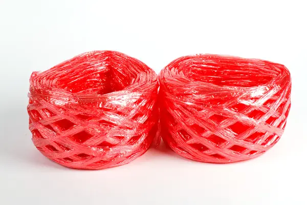 Rolka czerwonej wstążki z tworzyw sztucznych na białym tle — Zdjęcie stockowe