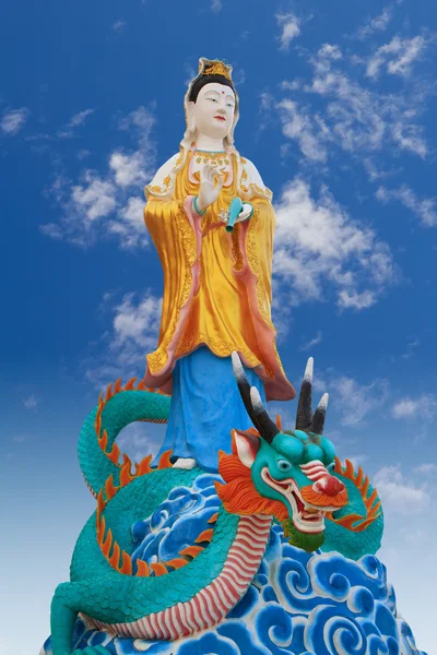 Гуань Инь верхом на зелёном драконе на голубом небе Стоковое Фото