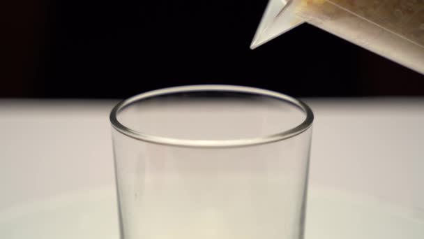 在一个空的透明玻璃杯中进行巴氏大米的批量抽水工艺 黄米对人体的好处 用于制备小牛肉的配料 特写镜头 — 图库视频影像