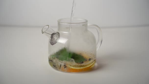 レモン オレンジ ミントの葉と紅茶とティーポットに沸騰水を入れてください 淹れ方 — ストック動画