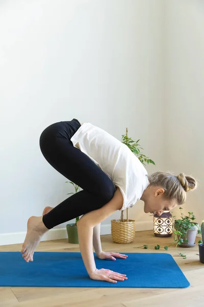 Caucasian woman is doing Bakasana Royalty Free Stock Photos