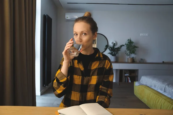 Girl at the desk, writing in the notebook 스톡 사진