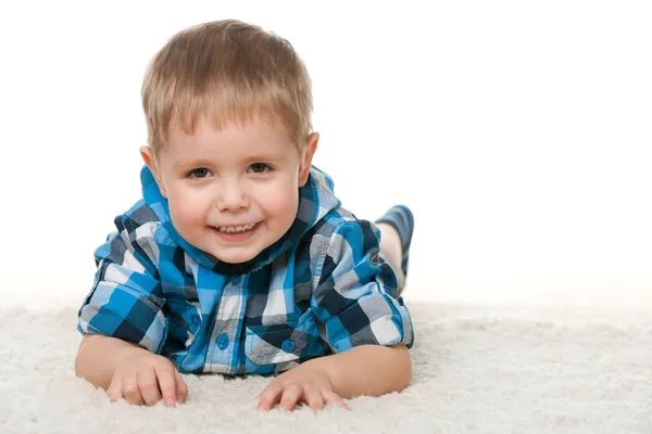 Веселий маленький хлопчик на білому килимі — стокове фото