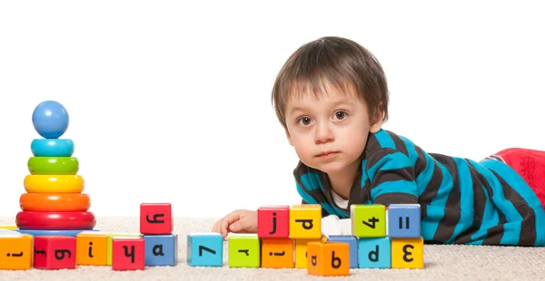 Little boy near blocks with alphabet — Stock Photo, Image