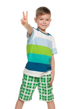 neşeli küçük çocuk zafer işareti gösterir