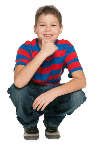 Красивый улыбающийся мальчик сидит на полу — стоковое фото