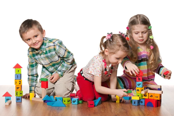 Трое детей играют на полу — стоковое фото