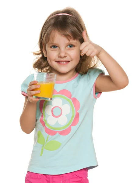 Liten flicka med ett glas apelsinjuice — Stockfoto