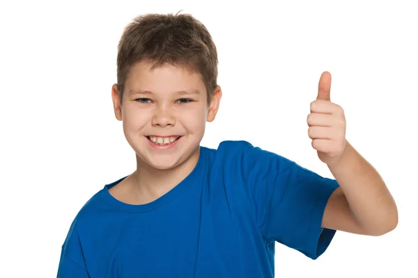 Smiling boy in blue shirt holding his thumb up — Stock Photo, Image