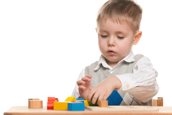 Serious little boy at the desk — Stock Photo, Image
