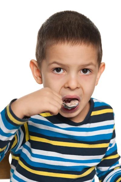 小さな男の子はスプーンで食べる — ストック写真