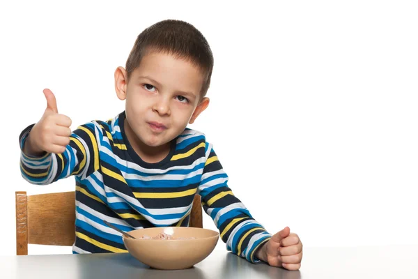 Petit garçon prend le petit déjeuner à la table — Photo