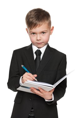 bir defter ile siyah elbiseli ciddi genç çocuk