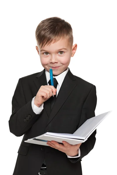 Young boy in black suit with a notebook — Stock Photo, Image