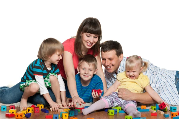 Родина грає з дітьми на підлозі — стокове фото