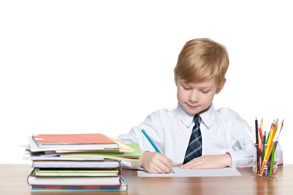 Νεαρό αγόρι γράφει στο γραφείο — Φωτογραφία Αρχείου