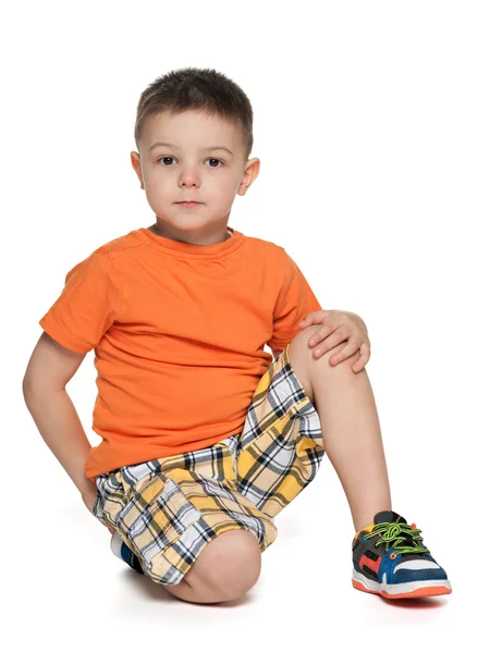 Serious little boy in the orange shirt — Stock Photo, Image