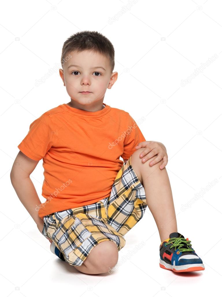 Serious little boy in the orange shirt