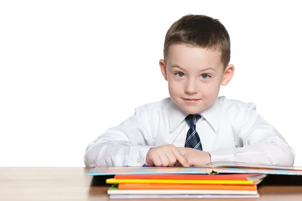 Schoolboy está lendo na mesa — Fotografia de Stock