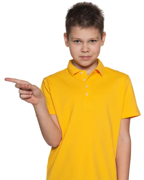 Junge im gelben Hemd zeigt Zeigefinger zur Seite — Stockfoto
